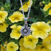 Silver sunflower pendant necklace among yellow flowers