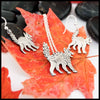 Silver Scaredy Cat necklace and earrings on red leaves with black stones in the background