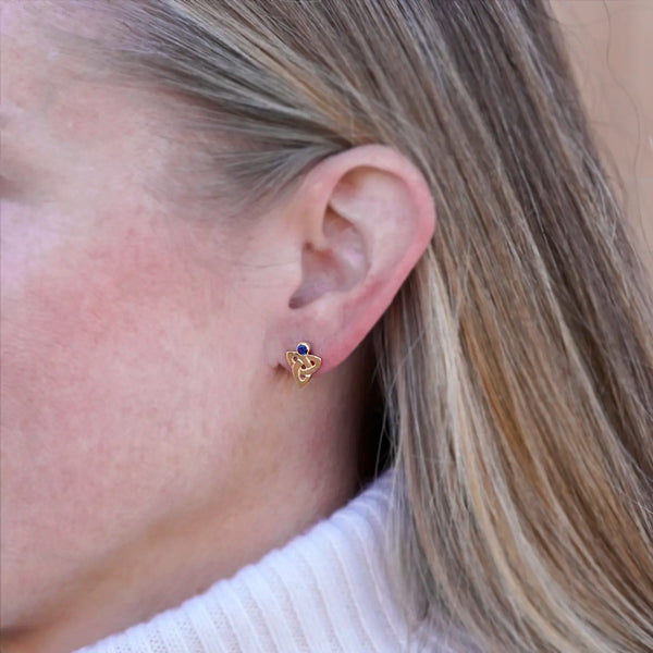Triquetra post earring in 14K gold with sapphire, worn on the ear