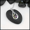 A small Tear Drop Frame in Sterling Silver. In the upper left is a Sterling Silver Oak leaf charm, below the Oak Leaf is a bezel set pink Tourmaline and a Sterling Silver beads. Filling the right side of the frame is an 18 Karat Yellow Gold Spiral. This pendant includes an 18" Cable Chain. Made by Sydney.