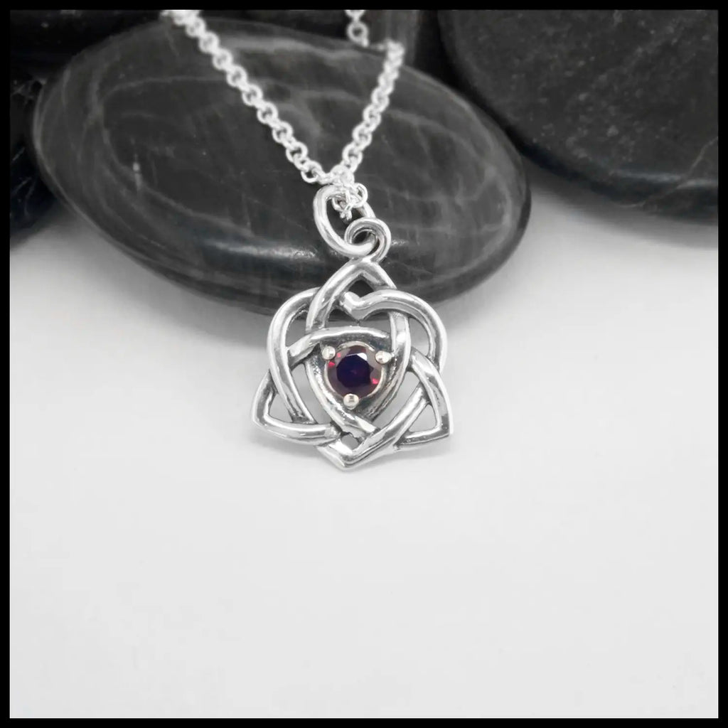 This lovely Limited Edition Trinity Knot Heart Pendant in Sterling Silver, set with 4mm Rhodolite Garnets. Includes 18" Cable Chain.