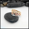 Three-toned ring on a black stone with a white background. Size 7 1/2.