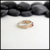 Side Profile 14K Rose Gold frame ring with 14K White Gold Rails,Set with a malaya garnet on a white background