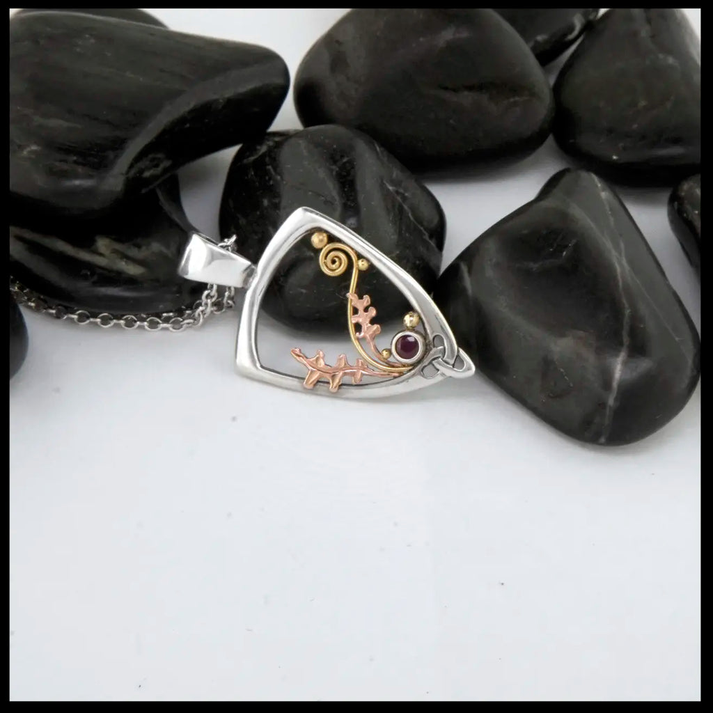 Silver Frame pendant with 14K rose gold oak leaves, 14K yellow gold spirals and beads. set with a 2mm ruby.