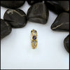 Gold ring with purple spinel on a white background with black stones