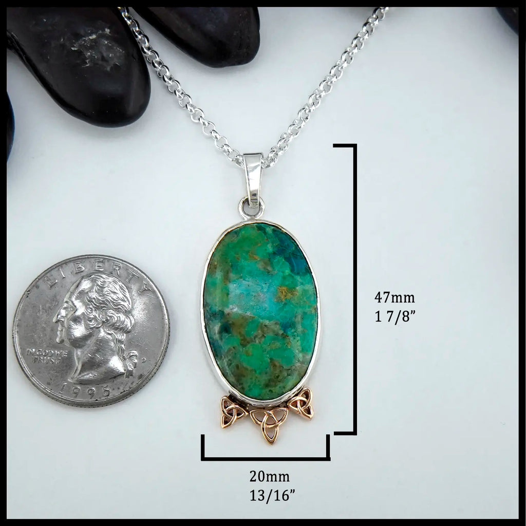 Chrysocolla pendant with silver and gold accents on a white background, shown with a quarter for scale. 47mm by 20mm