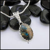 Silver pendant necklace with a stone pendant on a white background