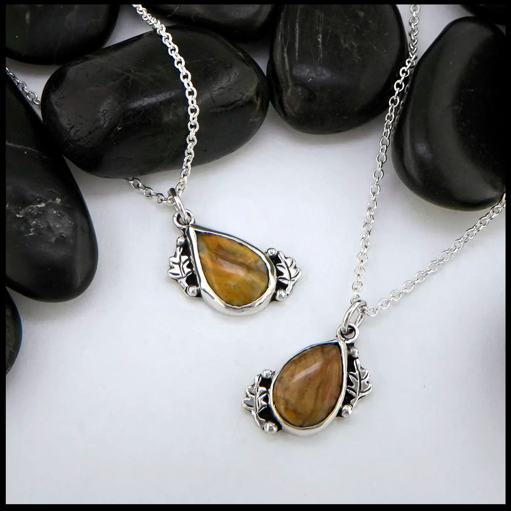 Petrified wood teardrop cabochon set in sterling silver with leaves.