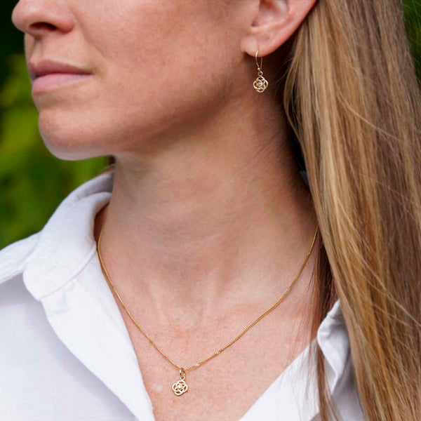 Dainty Josephine's Knot pendant and matching drop earrings in 14K gold with diamonds, worn
