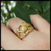 14K Yellow Gold ring with a detailed Scottish Thistle design on a leafy green backround.