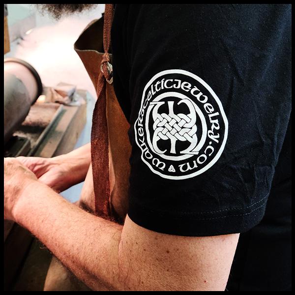 Person wearing T-shirt showing sleeve with Walker Metalsmiths Logo