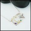 Custom Hummingbird and Flower pendant in Sterling Silver with 14K Yellow Gold Hummingbird, flower, and accent beads, set with an Amethyst, Tsavorite, and Rhodolite Garnet. Shown with an attached cable chain.
