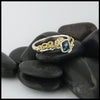 Custom 14K White Gold textured band with an 18K Yellow Gold cathedral design, set with a .59CT blue rose cut Diamond and a .06CT accent Diamond. 