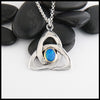 This sterling silver trinity knot features a black opal doublet set in a custom 14K yellow gold bezel. 