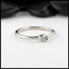 Simple 14K White Gold ring bezel set with a 0.09ct Emerald Cut Diamond.