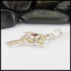 Profile view of garnet cross in silver and gold